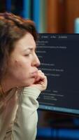 Vertical Cybersecurity specialist looking confused at computer screen while trying to fix broken code. Contemplative developer feeling worried and anxious about programming errors, camera A video