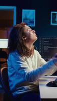 Vertical Admin listening music and writing lines of code filtering malicious traffic from cybercriminals attempting to steal company data. Woman wearing headphones while preventing malware, camera B video