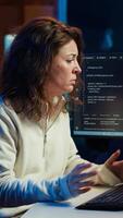 vertical cansado mulher machucando a partir de também Muito de estresse acumulado enquanto fazendo Programas qualidade garantia em computador. desenvolvedor sofre a partir de dor de cabeça depois de inspecionando codificação em pc para também longo, Câmera uma video