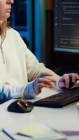 Vertical IT programmer listening music while fixing vulnerabilities in software compromising operating system. Cybersecurity expert wearing headphones and using PC to patch security exposures, camera A video