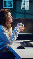 vertical retrato do sorridente isto especialista bebendo café enquanto olhando para companhia segurança vulnerabilidades e impedindo malware infecções. programador desfrutando quente bebida enquanto escrevendo código, Câmera b video