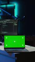 Vertical Admin using green screen laptop to implement security measures, protecting company systems and data. IT worker testing and debugging code for software applications on chroma key notebook, camera B video