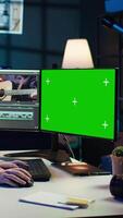 Vertical Videographer uses editing software on chroma key computer to assemble footage into final product. Woman color correcting clips on isolated screen PC to ensure project meets desired aesthetic, camera B video