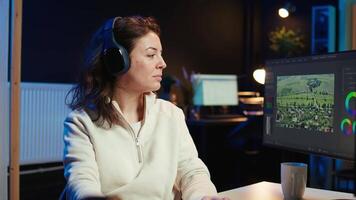 editor polishing raw footage, applying modern editing techniques in order to enhance sound and visual quality. Videographer adjusting clips while listening music in headphones, camera B video
