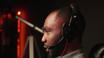 Close up of pro streamer streaming videogame on powerful computer during online gaming championship, talking into headset. Gamer taking part in Esport team of gamers, competing in game, camera B video