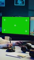 vertikal Foto redaktör använder sig av grön skärm övervaka till se på redaktionell bilder tagen med professionell kamera för mode tidskrift. frilansare bläddring bilder på attrapp pc, använder sig av grafisk läsplatta, kamera b video