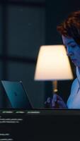 Vertical Developer doing software debugging using laptop, checking glitches in lines of code, upset about errors. Woman walking around home fixing coding issues using notebook device, camera A video