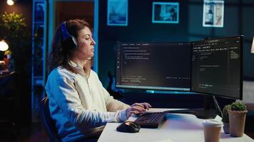 IT programmer listening music while fixing vulnerabilities in software compromising operating system. Cybersecurity expert wearing headphones and using PC to patch security exposures, camera B video