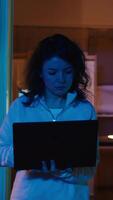 Vertical Computer scientist walking at home, developing software applications using laptop. IT professional standing in living room, implementing and maintaining company systems, camera B video