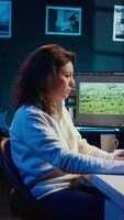 Vertical producer adds sound effects to film montage, working in studio, close up shot. Videographer using headphones to test and improve audio quality using specialized software, camera B video