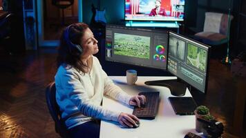 Freelancer adds sound effects to filmed footage, working in home studio. Post production specialist using headphones to test and improve audio quality using editing application, camera B video