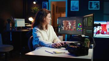 editor selecting key frames to use while doing montage, working from home on computer. Cheerful woman using mouse to edit movie project footage in office, camera B video