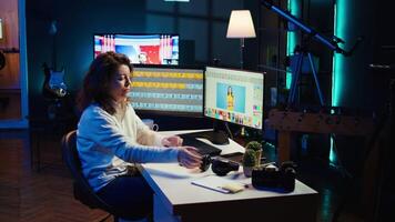 Freelancer editing images lighting and color balance, working in home studio while enjoying music. Photographer using headphones to listen favorite songs while using retouching software, camera B video