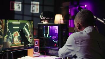 Man having fun playing videogames on PC while chatting with teammates. Excited gamer battling rival players, communicating with friends through headset microphone, camera B video