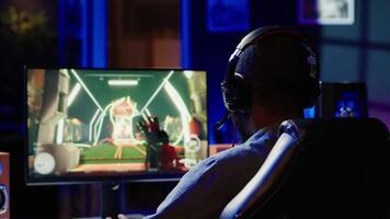 jugador utilizando teclado, ratón y auriculares a jugar primero persona tirador videojuego en ordenador personal, disfrutando ocio tiempo. hombre en vivo habitación utilizando alto tecnología computadora periféricos a destruir enemigos, cámara un video