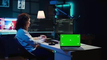 Admin using green screen laptop to implement security measures, protecting company systems and data. IT worker testing and debugging code for software applications on chroma key notebook, camera B video