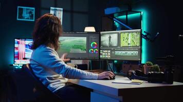 Videographer using editing software to assemble footage into cohesive final result while enjoying cup of coffee. Specialist color correcting clips while drinking hot beverage, camera B video