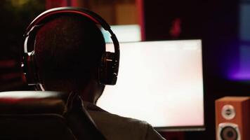 Man using headphones to enjoy online multiplayer spaceship videogame with friends, close up. Player communicating with teammates through headset mic, flying spacecraft, camera A video