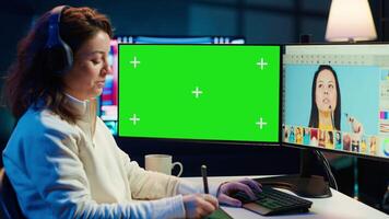 Photo editor using green screen monitor to color correct photographs in creative studio, listening music. Photographer selecting best pictures for editorial content with chroma key computer, camera A video