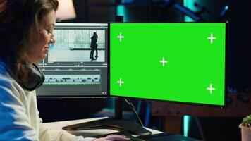 Freelancer works on isolated screen desktop computer on digital portfolio showcasing edited videos. editor selecting best clips using retouching application on chroma key display, camera A video