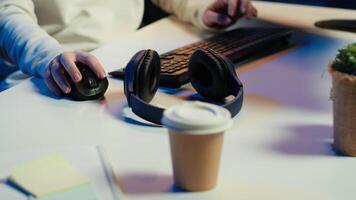 Admin listening music and writing lines of code filtering malicious traffic from cybercriminals attempting to steal company data. Woman wearing headphones while preventing malware, camera A video
