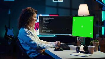 Developer doing software debugging on green screen PC at home, checking lines of code displayed on monitors. IT professional in living room fixing coding problems on mockup computer, camera A video