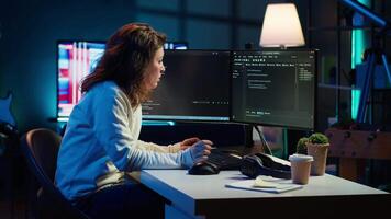 IT expert working from home developing software in JavaScript programming language using desktop PC. System engineer in living room writing lines of code on computer using keyboard, camera A video