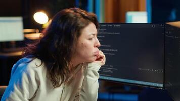 Cybersecurity specialist looking confused at computer screen while trying to fix broken code. Contemplative developer feeling worried and anxious about programming errors, camera A video