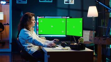 Photographer using photo editing software on chroma key multi monitors setup to improve images quality. Photo editor utilizing pictures retouching application on green screen display, camera A video