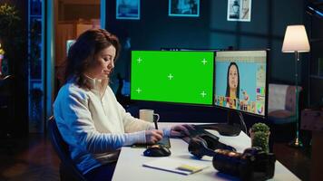 Photo editor using green screen monitor to look at editorial pictures taken with professional camera for fashion magazine. Freelancer browsing images on mockup PC, using graphic tablet, camera B video