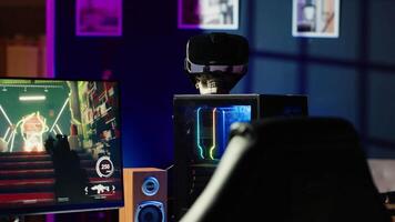 RGB lit parts on opened gaming PC tower next to keyboard, stereo speakers, display and high tech VR headset in empty apartment. Computer with modern hardware, monitor and virtual reality glasses video