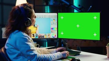 Photographer wearing headphones using advanced photo editing software on green screen monitor to upgrade images. Photo editor utilizing photographs retouching application on mockup PC, camera A video