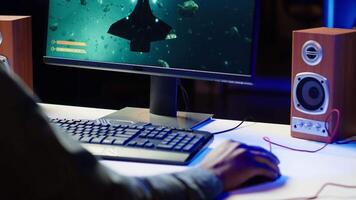 Man at home using high end computer system to play demanding science fiction videogame. Gamer enjoying high quality game, streaming it online, shooting laser beams with spaceship, camera A video