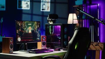 RGB lights illuminated components on open gaming PC tower next to computer peripherals, display and VR headset in empty apartment. Desktop PC in home living room, monitor and virtual reality glasses video