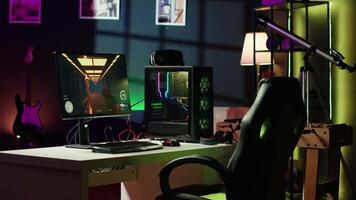 Professional gaming empty room studio with neon lights and RGB lit powerful computer, first person shooter game left open on screen. FPS videogame on pc display in apartment late at night video