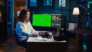 editor using editing software on green screen monitor to upgrade footage shot, commissioned by production teams outsourcing tasks. Freelancer videographer finishes project on mockup PC, camera B video