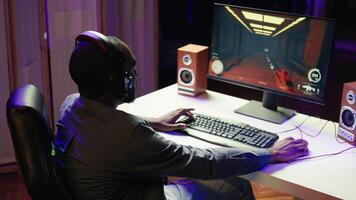 Pro gamer wearing headphones playing game, teaching audience esports needed skills. Content creator in gaming chair talking with audience, filming tutorial on how to defeat enemies, camera B video