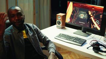 African american man teaching subscribers professional esports skills and how to play game. Media star on gaming chair chatting with viewers, filming gaming tutorial, camera B video