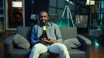 Irked gamer annoyed after losing in online singleplayer videogame played using controller. Man frustrated after failing to win game while playing on console with gamepad, camera B video