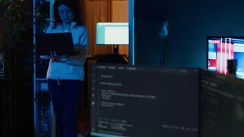 Computer scientist walking at home, developing software applications using laptop. IT professional standing in living room, implementing and maintaining company systems, camera A video