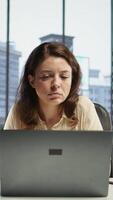 Vertical Successful businesswoman analyzes data and market trends on laptop, maximizing income, optimizing expenses and ensuring the company budget. Success story in a global business landscape. Camera B. video