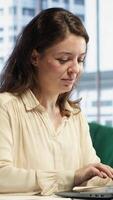 Vertical Female CEO solving her business paperwork tasks and signing documents, approving requests from employees and authorizing work contracts in her high end office. Legal management. Camera A. video