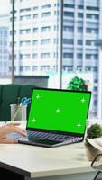 Vertical Business director working in her own office with green screen, looking at device display and developing a new project idea. Female entrepreneur empowered by corporate culture. Camera A. video