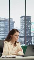 Vertical Powerful female leader grabbing her headphones for productivity in a smart office, listening to an audiobook and networking for effective communication to drive corporate results. Camera B. video