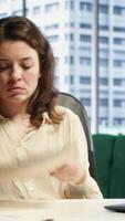 Vertical Female entrepreneur working on her legal obligations to sign paperwork and work contracts, approving all documents for performance and productivity. Businesswoman CEO gives authorizations. Camera A. video