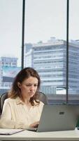Vertical Stressed woman entrepreneur suffering form a migraine from workload and fatigue, feeling tired and worried about the business activity. Overworked leader deals with burnout and discomfort. Camera B. video