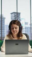Vertical Business entrepreneur enjoys working with music on her headset, solving daily tasks at her corporate office. Determined powerful female CEO having fun with favorite songs, productivity. Camera B. video