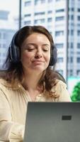 Vertical General director woman having fun listening to songs and dancing in her own office, enjoying executive power in a corporation. Confident happy CEO singing and working. Camera A. video