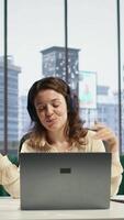 Vertical General director woman having fun listening to songs and dancing in her own office, enjoying executive power in a corporation. Confident happy CEO singing and working. Camera B. video