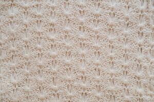 Close-up of the texture of knitted woolen fabric in beige color photo